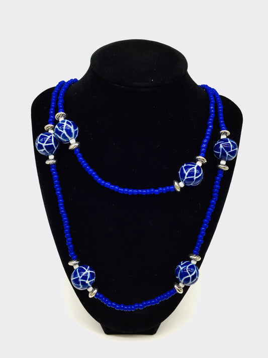 20 inches of blue seed beads, porcelain balls and silver accents.
